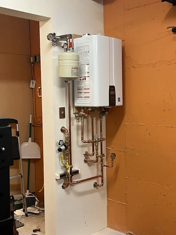 Plumbing technician inspecting water heater connections in Silverton